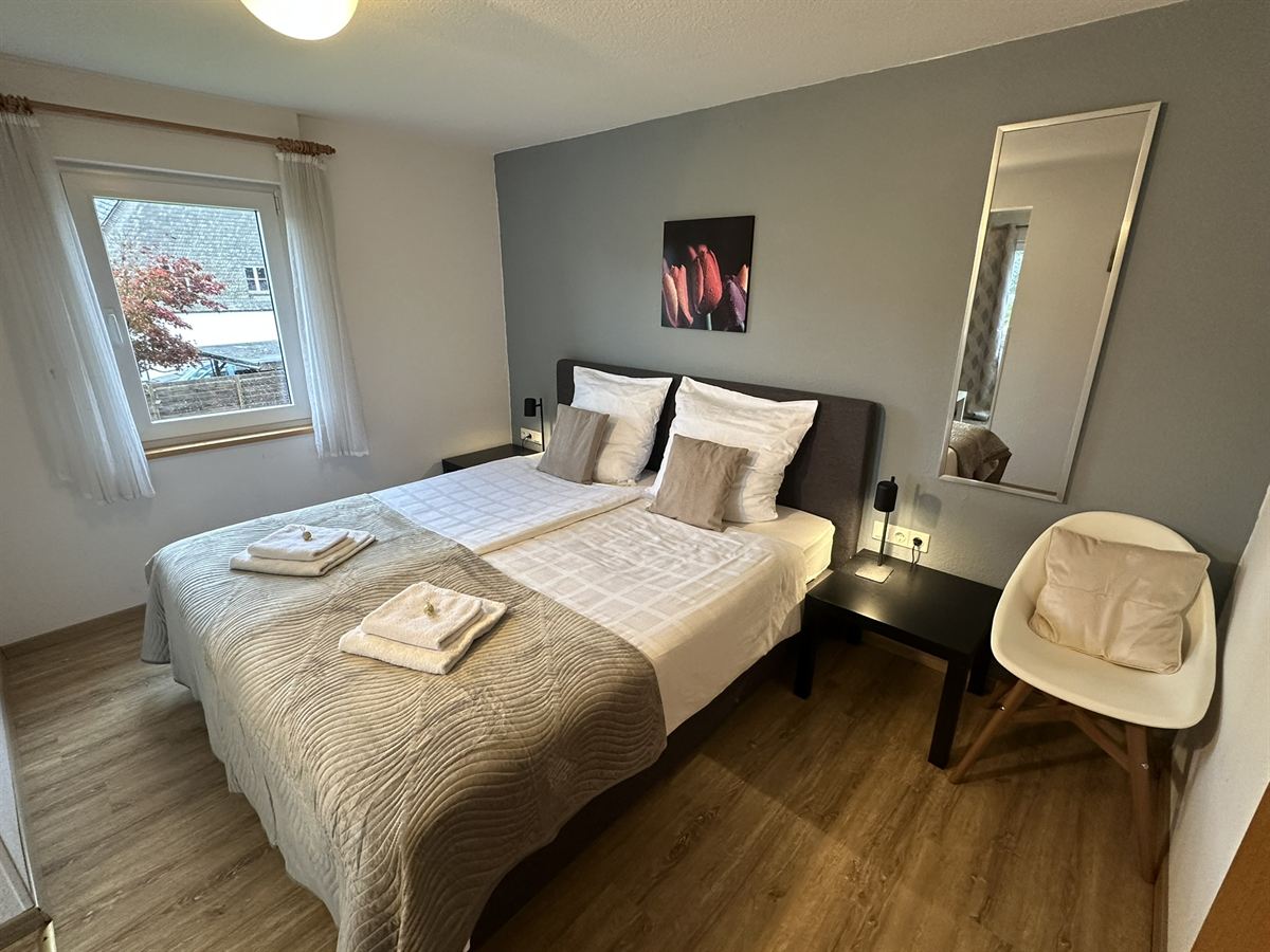 Helles Zimmer mit Boxspringbett in der Pension Haus Astenalm